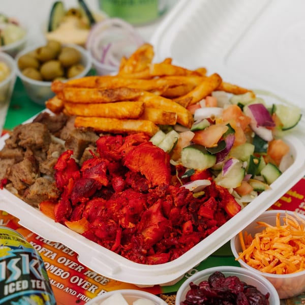 A Halal Munchies combo platter with red chicken, gyro meat, fries, and salad, with sides.